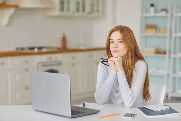 Schöne rothaarige Mädchen mit Laptop zu Hause. Online-Arbeit, Wirtschaft, Bildung oder Kommunikation — Stockfoto