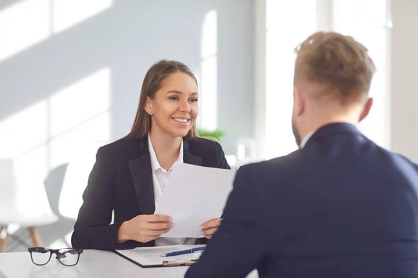 Una entrevista exitosa. Empleadora positiva escucha a un solicitante de empleo sentado en una mesa en la oficina . — Foto de Stock