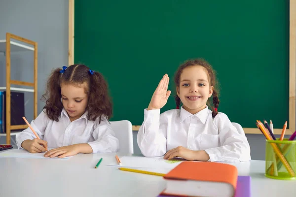 De vuelta a la escuela. Colegialas en una conferencia sentadas a la mesa en el aula . — Foto de Stock