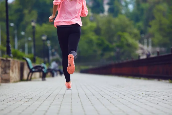 A mulher do desporto está a correr no parque. Visão traseira da menina em sportswear correndo ao longo ribeirinha . — Fotografia de Stock