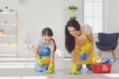 Mutlu gülümseyen aile oturma odasını temizler.