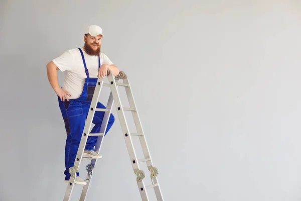 Baumeister lustiger Mann Arbeiter. Entzückte männliche Bauarbeiter auf Metallleiter. — Stockfoto