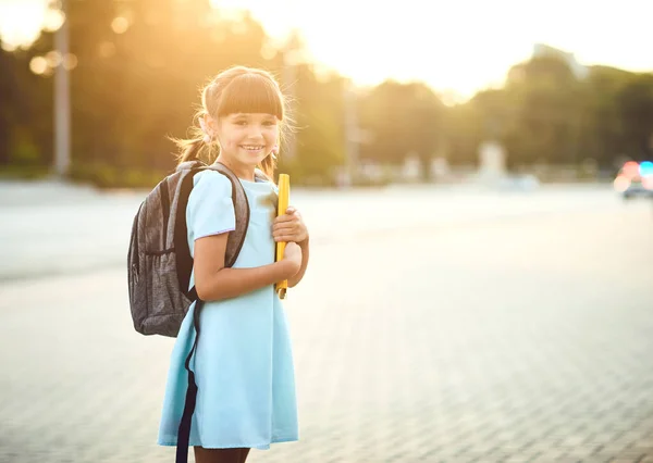 Bonne petite écolière avec un sac à dos sur le chemin de l'école. — Photo