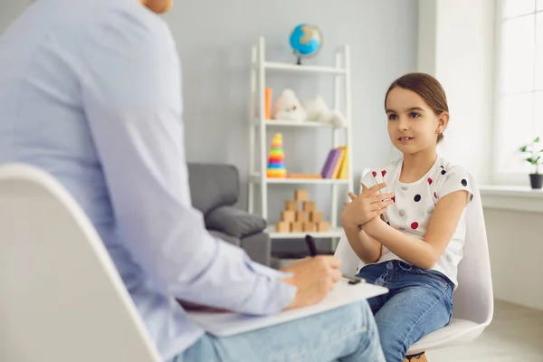 Aardig meisje dat praat met kinderpsychotherapeut op kantoor. Behandeling van geestelijke gezondheidsproblemen — Stockfoto