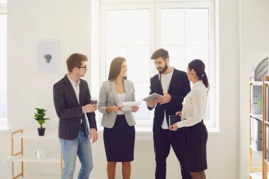 Genç iş adamları ofiste yeni bir başlangıç projesi için yeni fikirler veriyorlar..