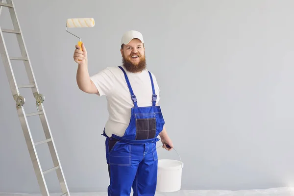 Peinture de peintre. Drôle de peintre masculin avec un patineur à roulettes debout peint en arrière-plan . — Photo