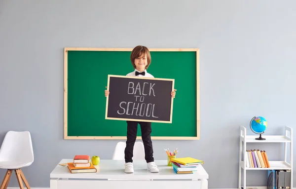 De volta à escola. Um estudante está segurando um quadro em suas mãos . — Fotografia de Stock