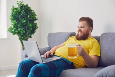 Çevrimiçi konferans görüntülü konuşma. Arkadaşlarla çevrimiçi parti. Komik adam elinde birayla bir bardak tutuyor, arkadaşlarıyla iletişim kuruyor. Evdeki görüntülü konuşma..