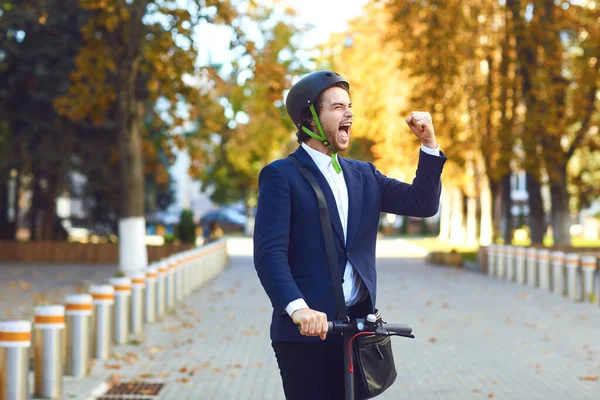 Junger Mann mit Helm fährt im Sommer mit einem Elektroroller auf einer Stadtstraße — Stockfoto