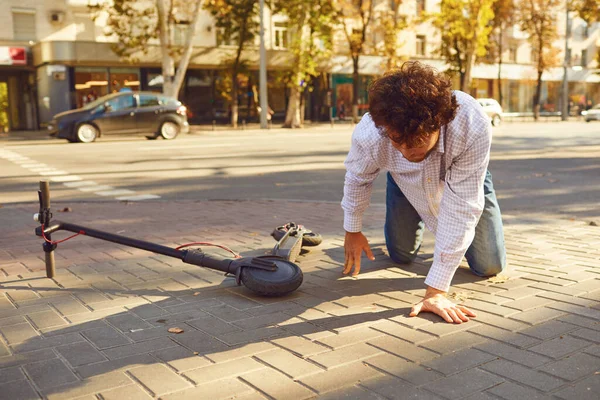 Accident with an electric scooter. A man fell from a scooter on a city street.