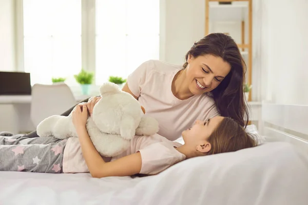 Selamat Hari Ibu. Ibu dan anak memeluk saat berbaring di tempat tidur di interior rumah putih. — Stok Foto