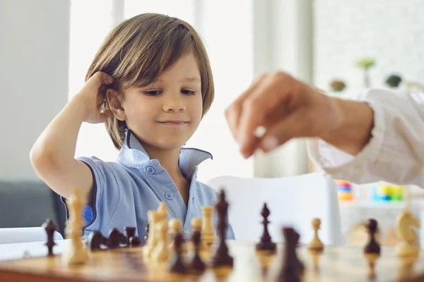 Anak kecil yang manis bermain catur dengan ibunya di rumah. Lucu anak menikmati permainan papan strategi dengan indoor induknya — Stok Foto