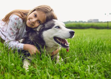 Evcil köpek ve çocuklar. İri köpek arkadaşlığı ve sarışın kız çocukları parkta yürüyüşe çıktılar..