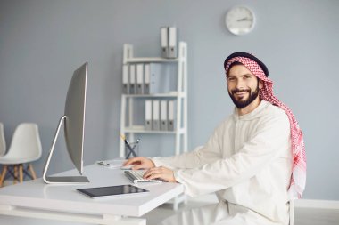 Arap işadamı ofisteki bilgisayarda çalışıyor..