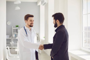 El sıkışalım. Klinikte doktor ve hasta el sıkışıyor, gülümsüyor..