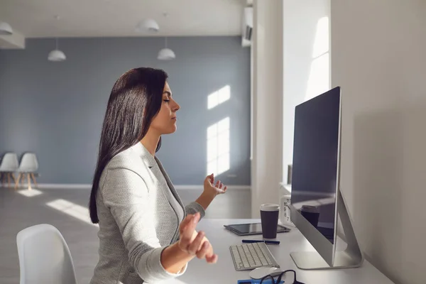 Vue de derrière. Femme d'affaires brune médite sur le lieu de travail à la table au bureau . — Photo