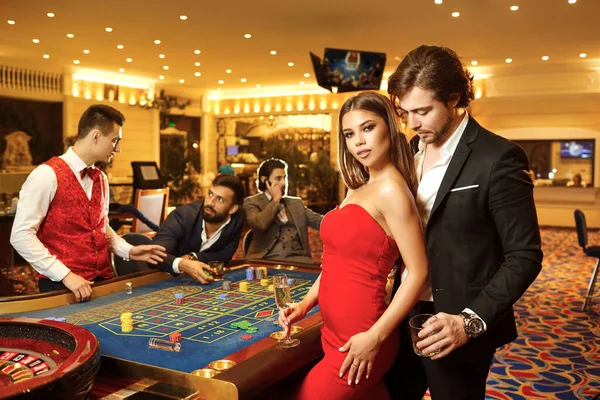 Casino poker rulet arka plan karşı güzel glamour çift. — Stok fotoğraf