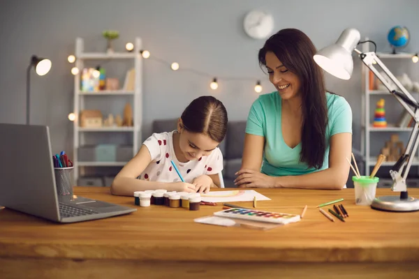 Educación en línea de los niños. Madre e hija de preescolar viendo una video lección llamada chat curso creativo dibujo de arte usando lapott en casa. —  Fotos de Stock