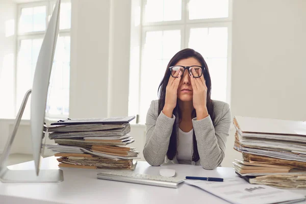 Er is veel werk op kantoor. Moe drukke zakenvrouw werkt met computer. — Stockfoto