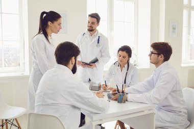 Toplantıda bir grup doktor klinikte duran bir hastanın teşhisini tartışıyor..