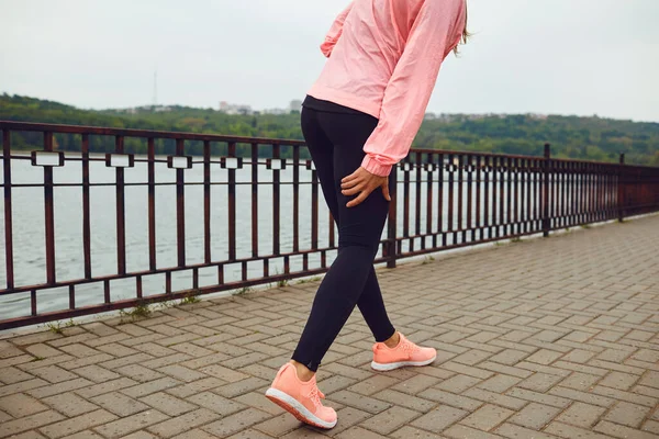 Deportiva que sufre de dolor en la pierna durante su entrenamiento al aire libre, espacio en blanco. Corredor con lesiones deportivas fuera — Foto de Stock