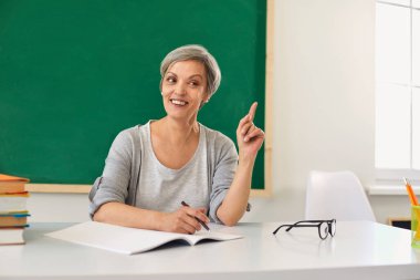 Pozitif kıdemli öğretmenler bir okulda öğretmenlik yaparken parmağını kaldırdı..