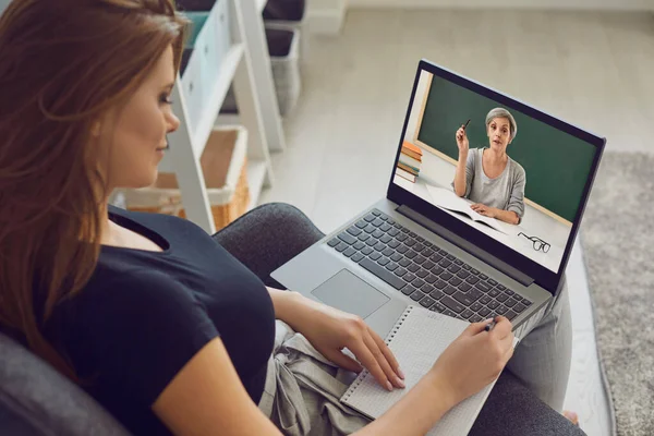 Online oktatás. Egy lány előadást tart egy videóleckével, egy laptop konferenciát egy tanárral, távolról, otthon. — Stock Fotó