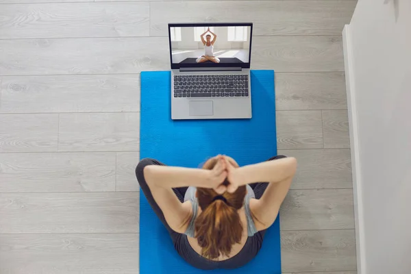 Curso de yoga en línea. Chica practicando videollamada portátil portátil yoga meditación sentado en el suelo en interiores — Foto de Stock