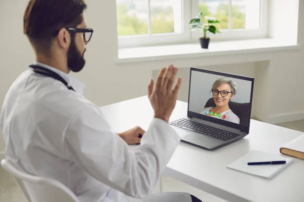 Doktor online. Starsza kobieta pacjent mówi objawy choroby do lekarza za pomocą laptopa wideo czat konsultacja wirtualna klinika. — Zdjęcie stockowe