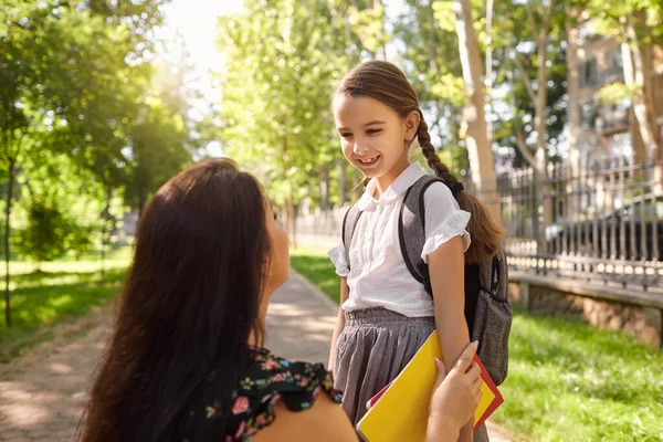 Je retourne à l'école. Petite fille avec sac à dos et sa mère sur le chemin de l'école le jour ensoleillé. — Photo