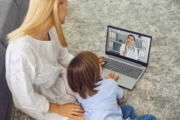 Mãe com filho conversando com o médico on-line de casa. Pais e garotinho fazendo videochamada com pediatra no laptop — Fotografia de Stock