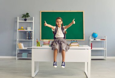 Kola kavramına geri dönelim. Sınıfta kitaplarla oturmuş gülümseyen mutlu okul kızı..