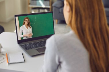 Çevrimiçi dil okulu. Genç bir kadın laptopuyla evden İngilizce dersi izliyor. Webinar 'a katılan öğrenci