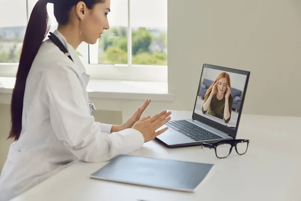 Online doctor and patient. Patient girl with a headache makes a video call to a doctor using a computer webcam.