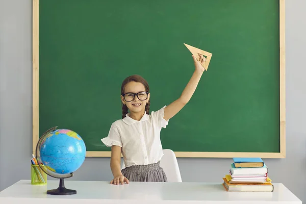 Una colegiala con gafas sonríe en el fondo de la pizarra escolar. Aprender educación estudiando en la escuela liceo universidad para niños — Foto de Stock