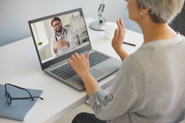 Siber tıp. Olgun bir kadın evinden doktorla konuşuyor. Web kamerasında kıdemli bir hastaya danışmanlık yapıyor.