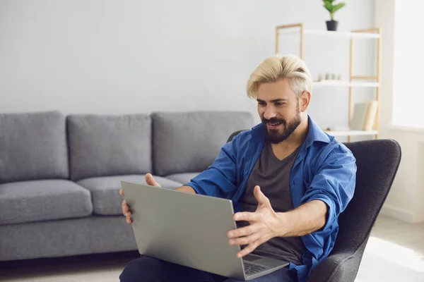 Der Kerl arbeitet zu Hause mit einem Laptop. — Stockfoto