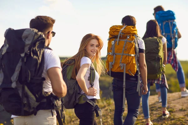 Skupina mladých turistů kráčí na kopci v přírodě. — Stock fotografie