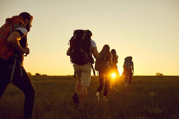 Fırlat. Yürüyüş. Turizm. Sırt çantalı bir grup turist yazın günbatımında tepe boyunca yürüyorlar.. — Stok fotoğraf