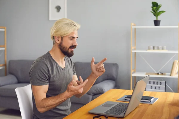 Mann Geschäftsmann mit Brille in legerer Kleidung arbeitet sprechenden Videoanruf Chat mit Laptop, während er an einem Tisch in der Wohnung sitzen. — Stockfoto