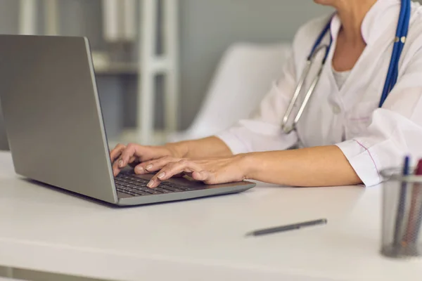 Concepto médico en línea. Médicos manos están escribiendo en un teclado portátil un mensaje web chat consulta clínica médica . — Foto de Stock