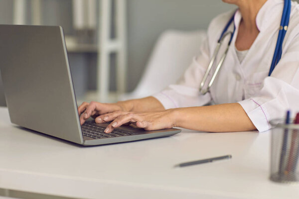 Concept doctor online. Doctors hands are typing on a laptop keyboard a message web chat consultation medical clinic.