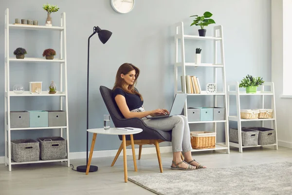 Жінка має комп'ютер відео виклику ноутбука онлайн сидить в кріслі вдома . — стокове фото