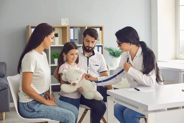 Een huisarts controleert een kind met een stethoscoop in een medische kamer. — Stockfoto
