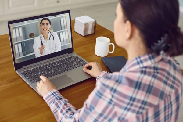 Consulta médica online. Paciente feminina olhando para monitor de laptop tem videoconferência on-line com médicos na sala — Fotografia de Stock