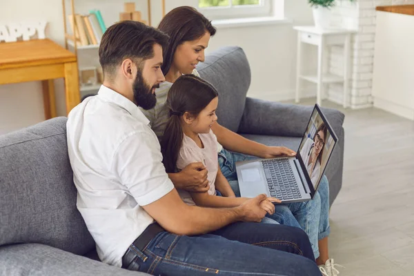 Médico de familia online. Familia feliz consulta utilizando la computadora de videoconferencia en casa. — Foto de Stock