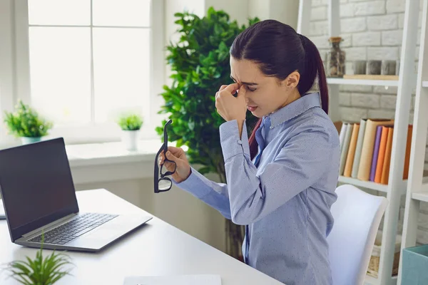 Cansada empresária esfregando nariz após trabalho duro no laptop . — Fotografia de Stock