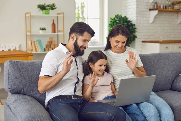 Happy online family uses laptop at home.