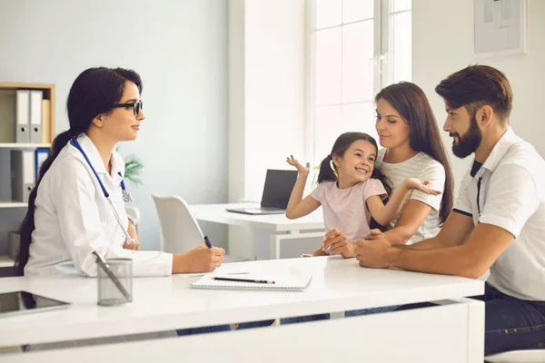 Familia feliz en una consulta médica con un médico en una clínica. —  Fotos de Stock