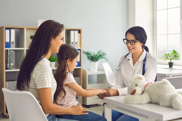 Moeder en baby bezoeken de dokter in het kliniek kantoor. Familiearts vrouw spreekt met familie in ziekenhuis — Stockfoto